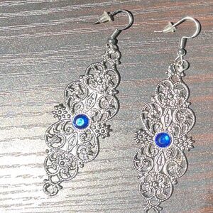 Silver filigree dangling earrings with blue stone